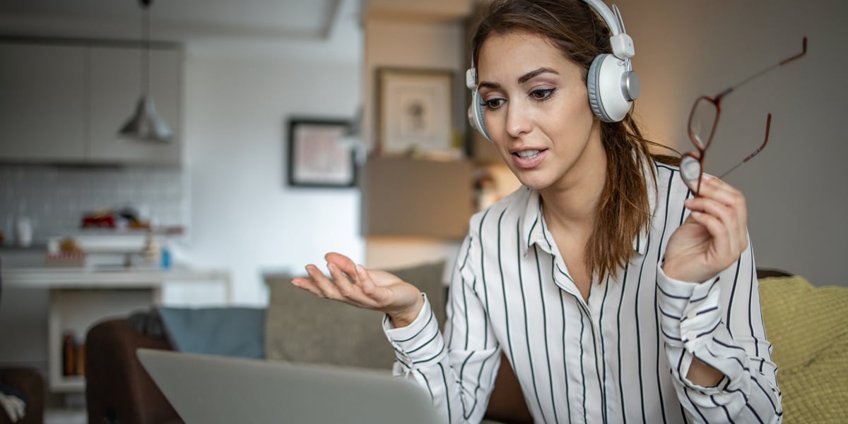 woman with headphones taking a virtual meeting from home